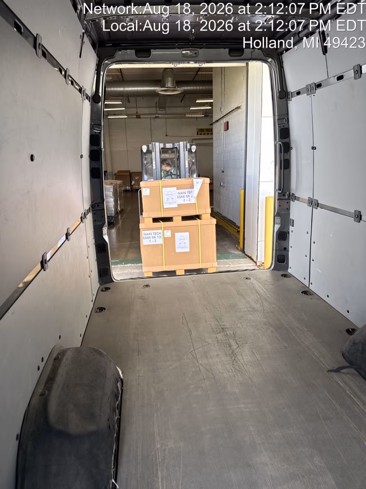 View from inside an empty Sprinter cargo area toward pallets just delivered onto a dock in Holland, Michigan
