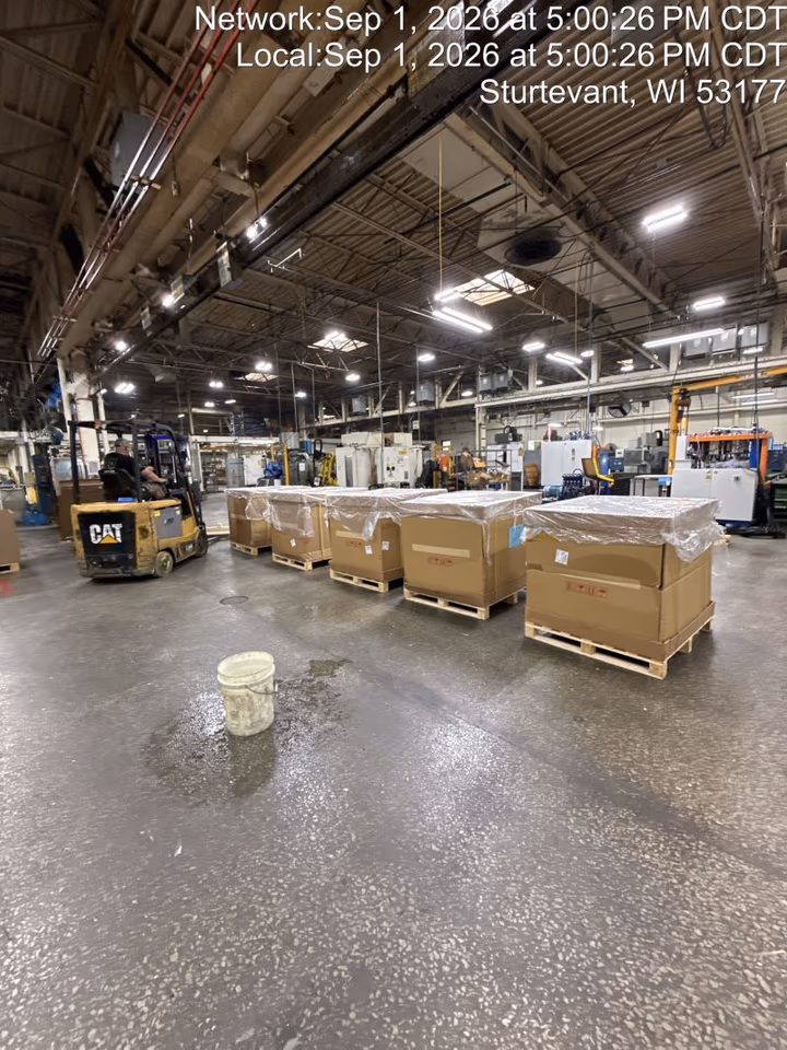 A row of five crated pallets lined up on a plant floor in Sturtevant, Wisconsin beside a forklift after a dedicated O’Hare recovery
